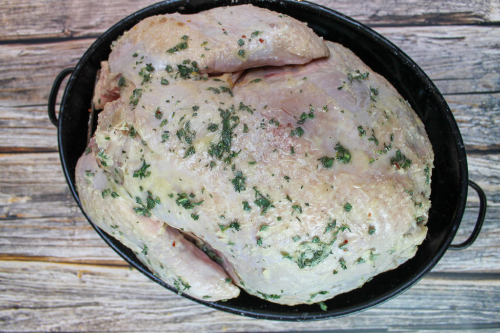 brined turkey before baking in pan with herb butter