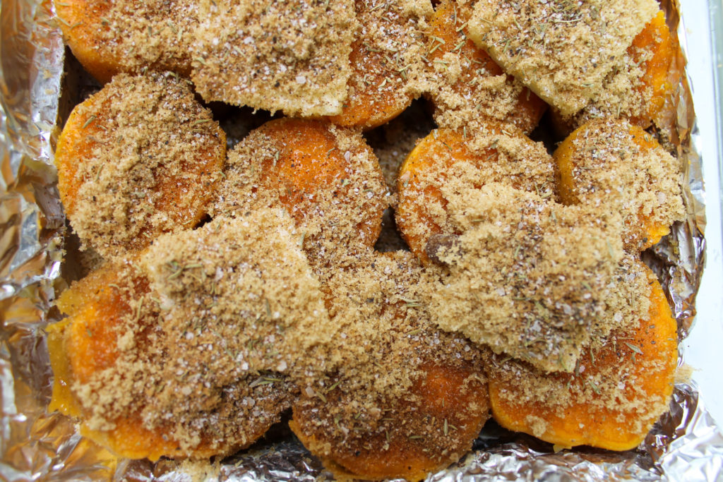 Sweet potatoes in baking pan with spices and butter