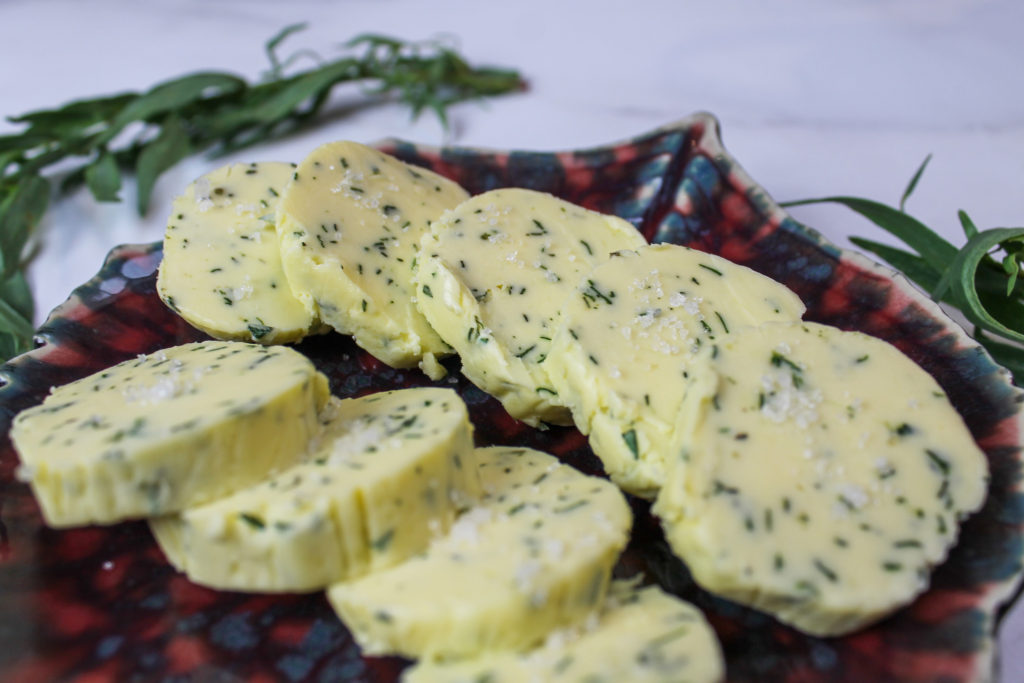 tarragon herb compound butter on a tray with tarragon around