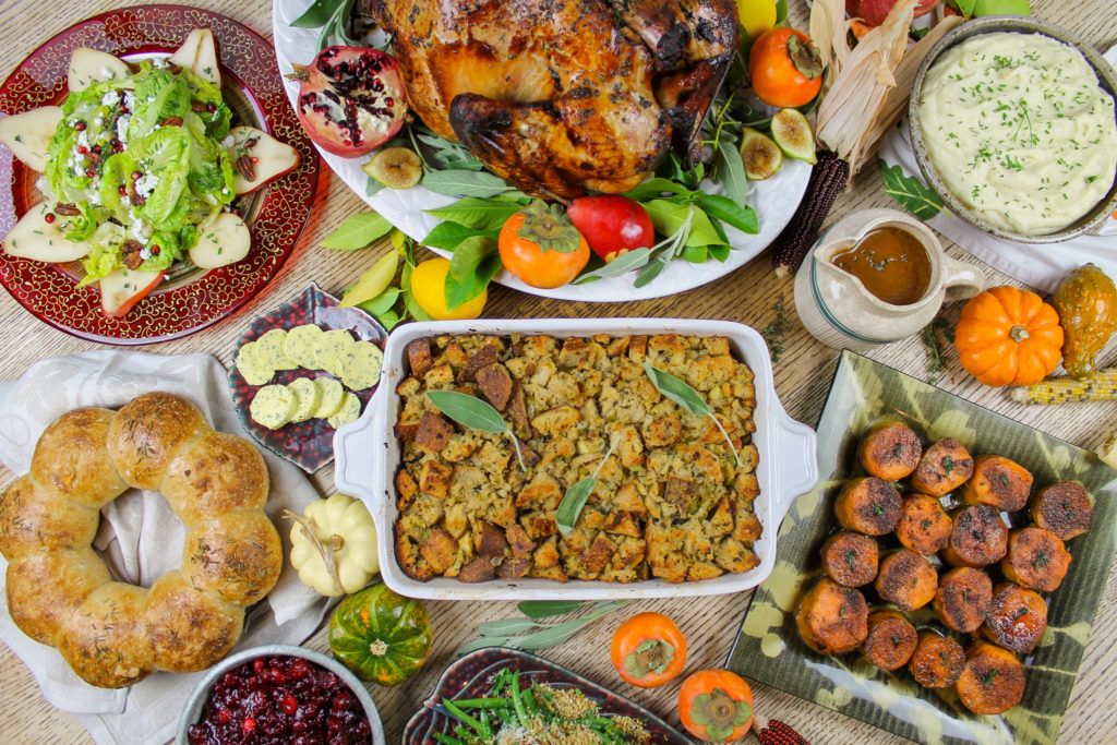 thanksgiving table with turkey, salad, potatoes, cranberry sauce, stuffing