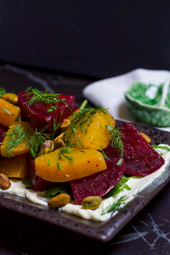 beet salad topped with herbs and pistachios