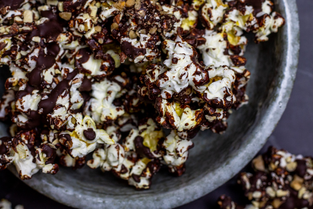 chocolate toffee popcorn with almonds in grey bowl