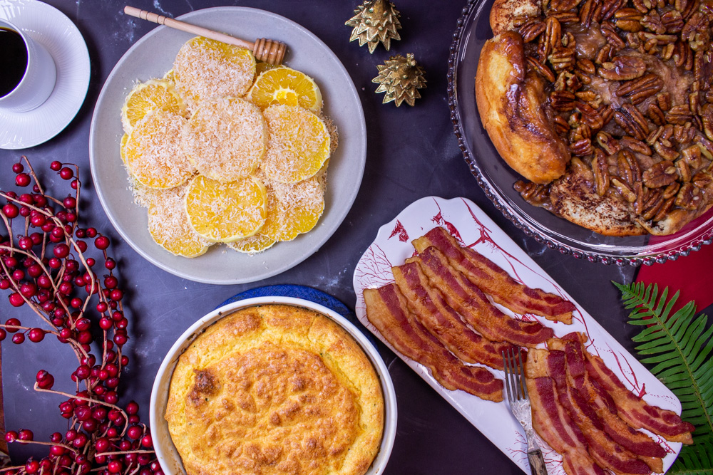 Christmas breakfast table egg souffle, sticky pecan rolls, oranges and bacon 