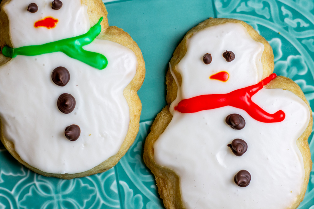 iced snowman cookies on blue plate