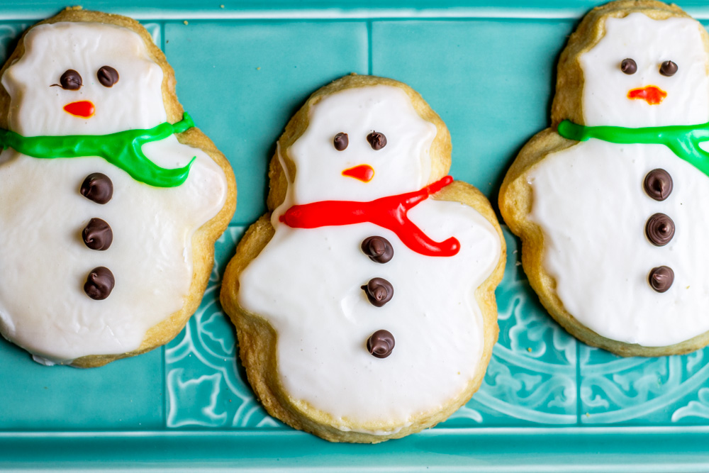 iced snowman cookies on blue plate