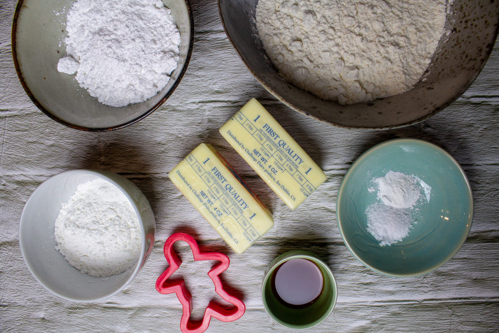 ingredients for christmas cookies: butter, cornstarch, powdered sugar, salt, vanilla, and flour and cookie cutter