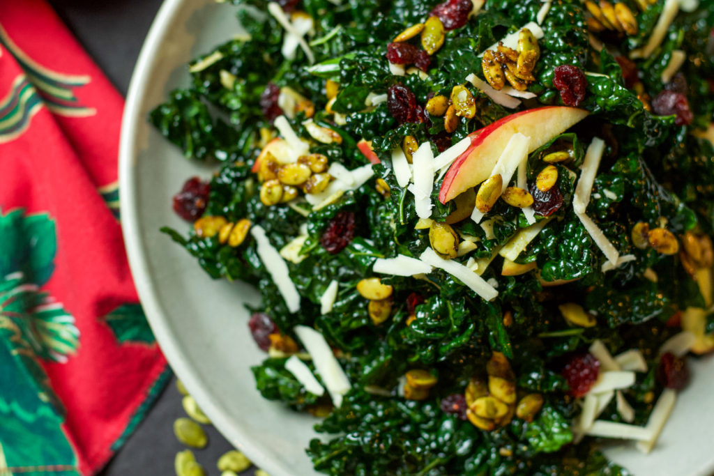 kale salad with cranberries, cheese, pumpkin seeds, and apples