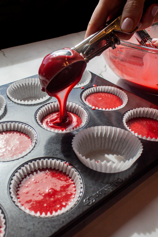 pouring red velvet cupcake batter